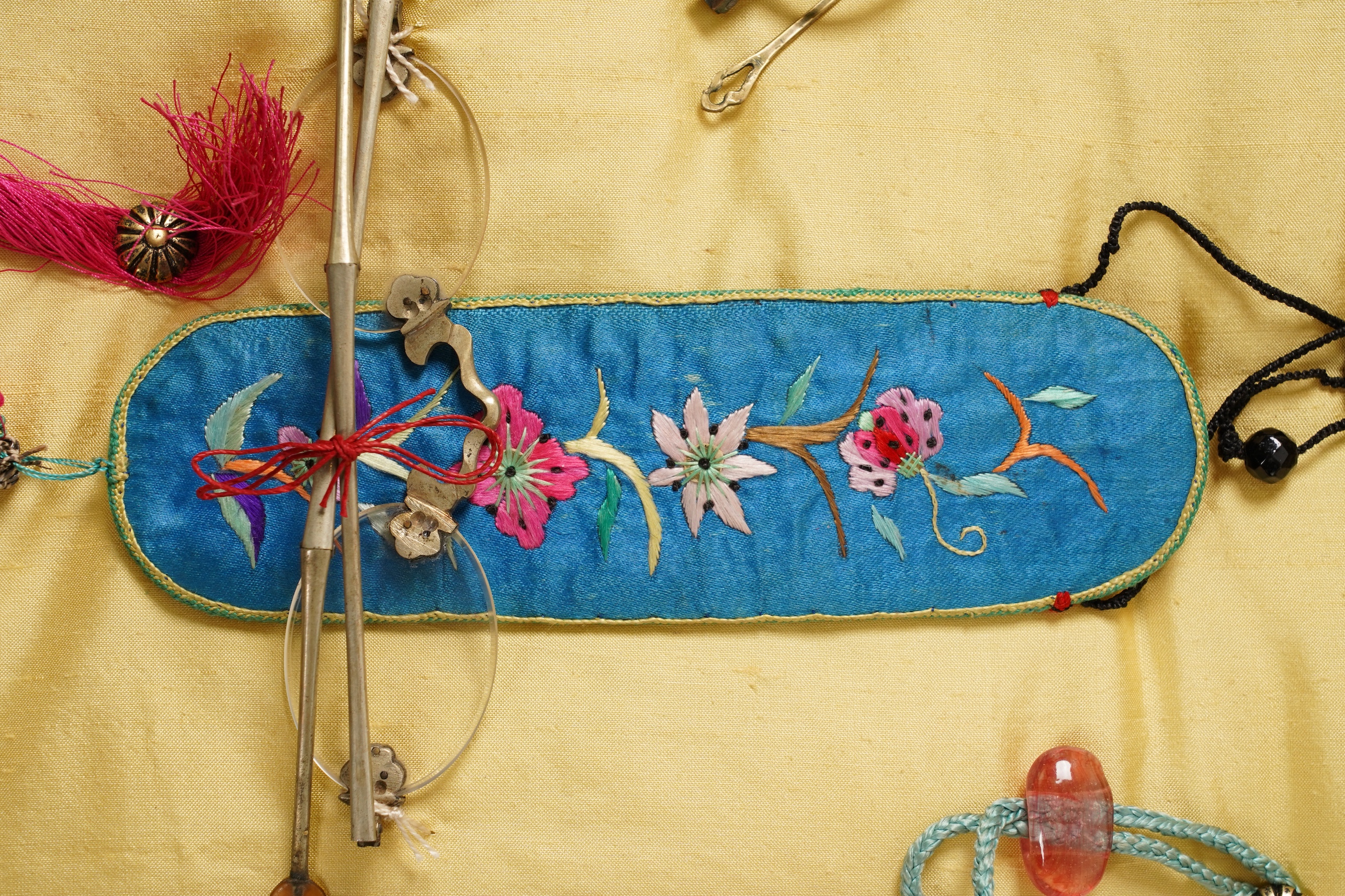 A collection of 19th/20th century Chinese embroidered silk spectacle cases and various spectacles, Box 33cm square